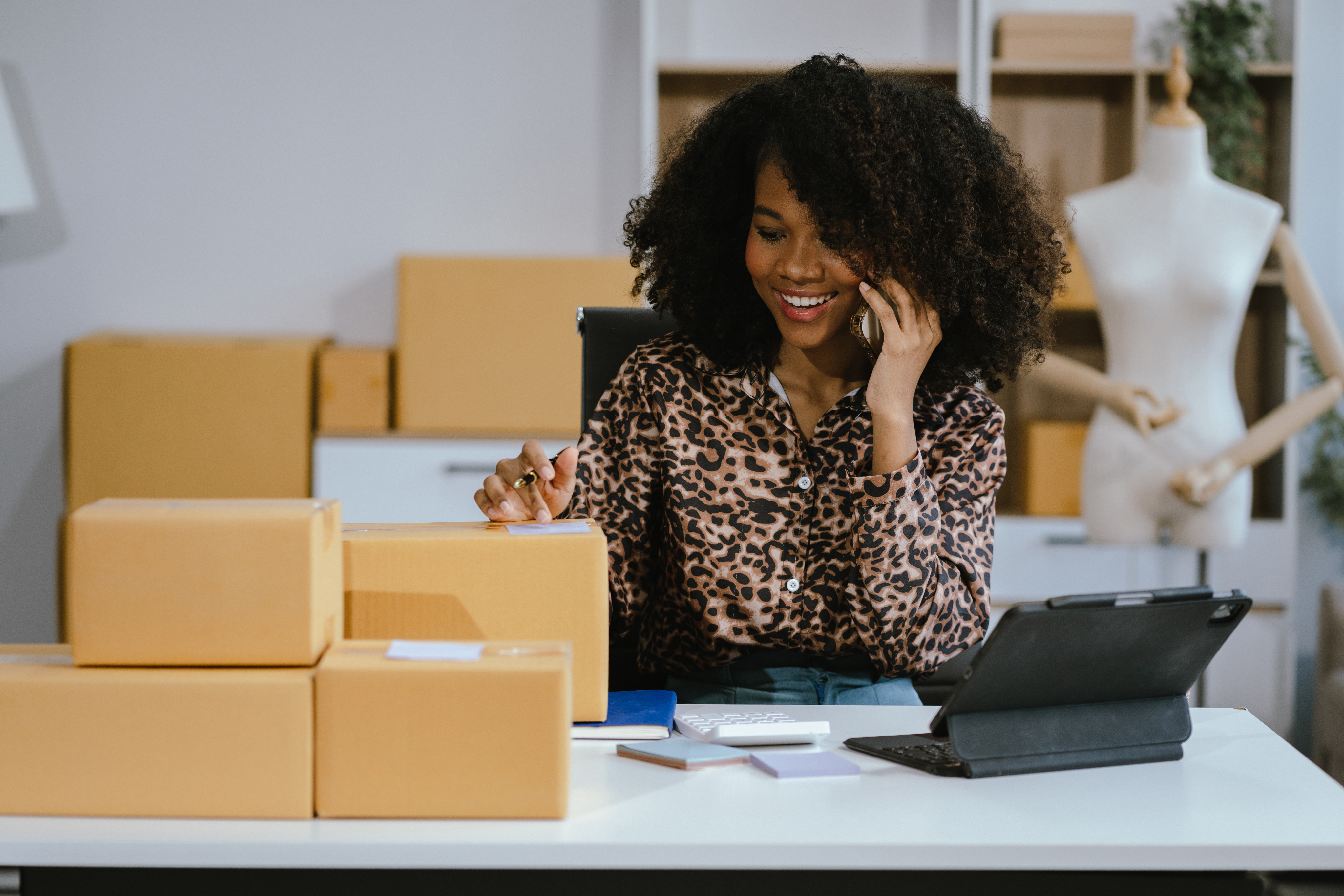 Woman on phone with packages at desk