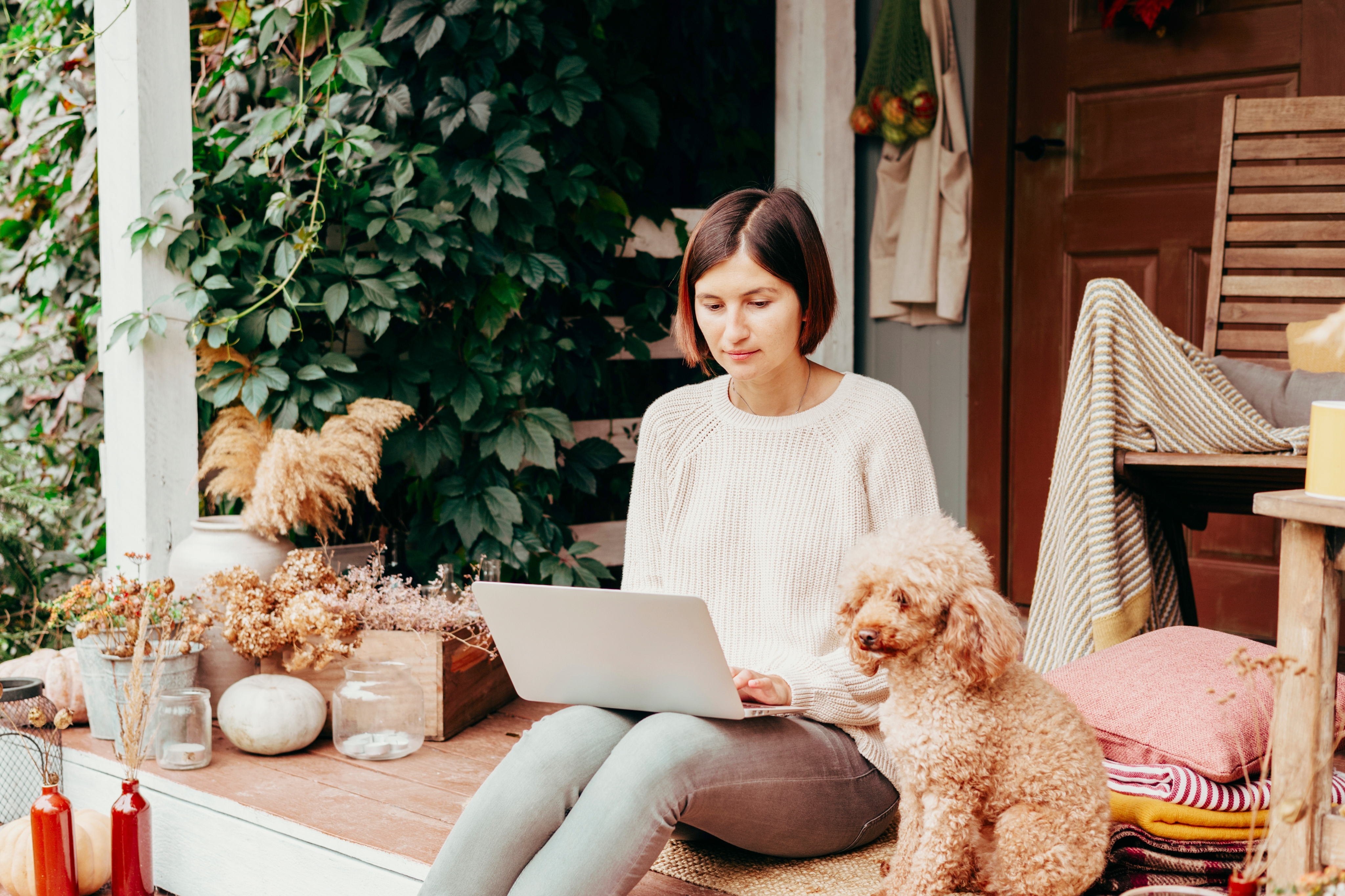 Woman working on laptop with dog